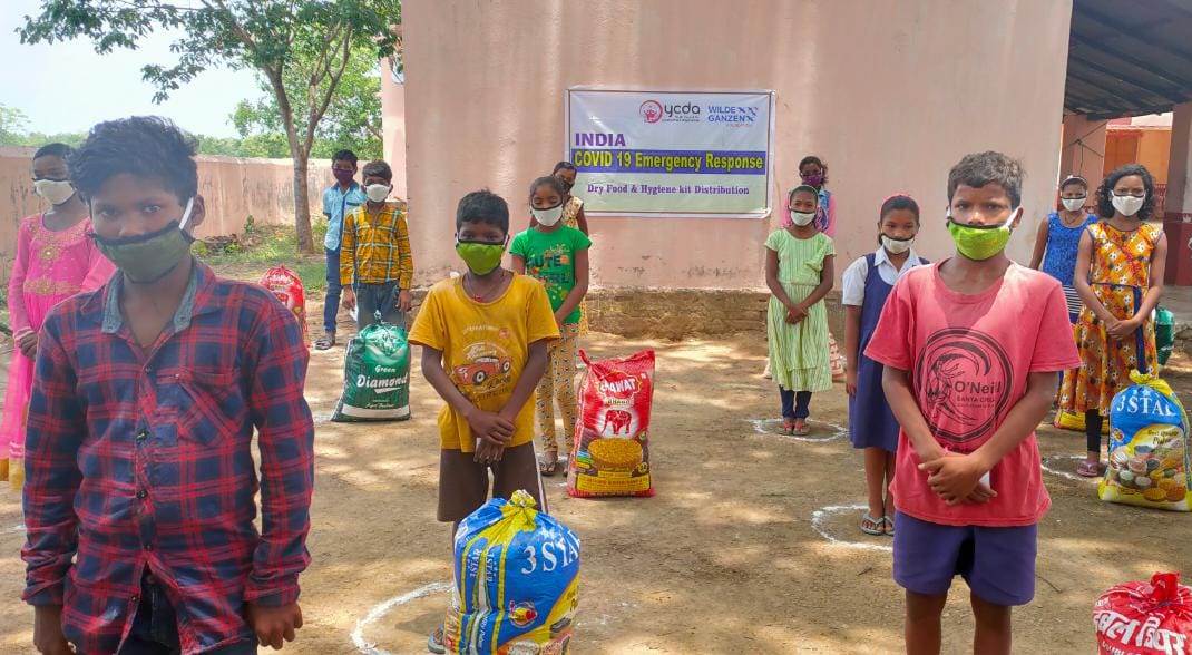 Een groep kinderen staan in cirkels om anderhalve meter afstand te houden.