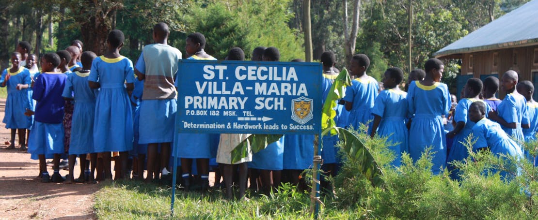 Kinderen staan in de rij voor hun basisschool in Oeganda