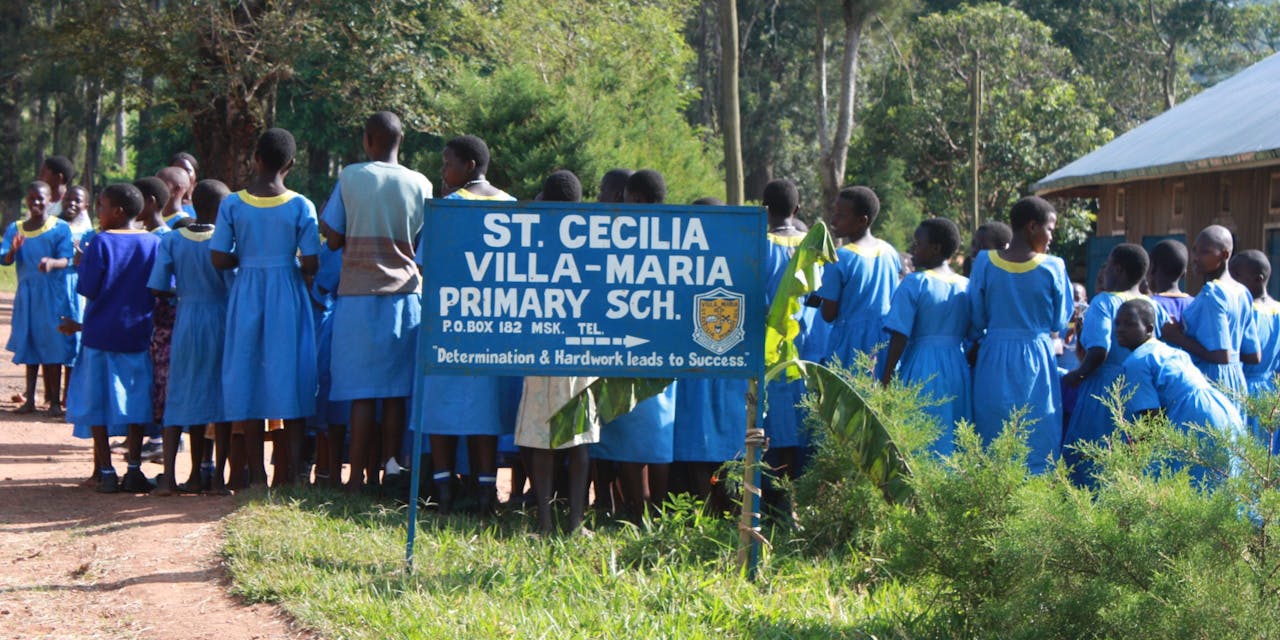 Kinderen staan in de rij voor hun basisschool in Oeganda