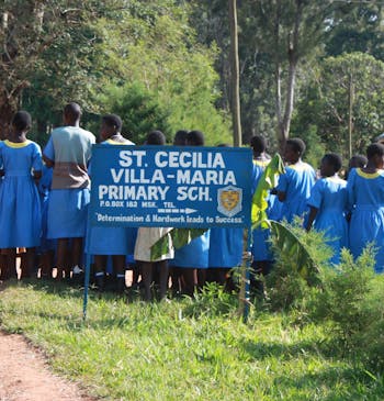 Kinderen staan in de rij voor hun basisschool in Oeganda