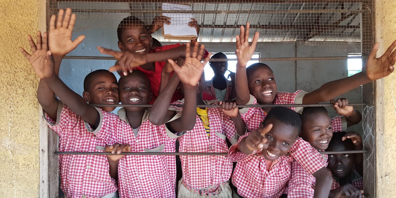 Een groep schoolkinderen met roze schooluniformen in Gambia.