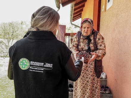 Een weduwe van Srebrenica krijgt een pak dadels.