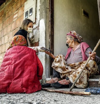 Een oude weduwe krijgt voedsel uitgereikt in Srebrenica.