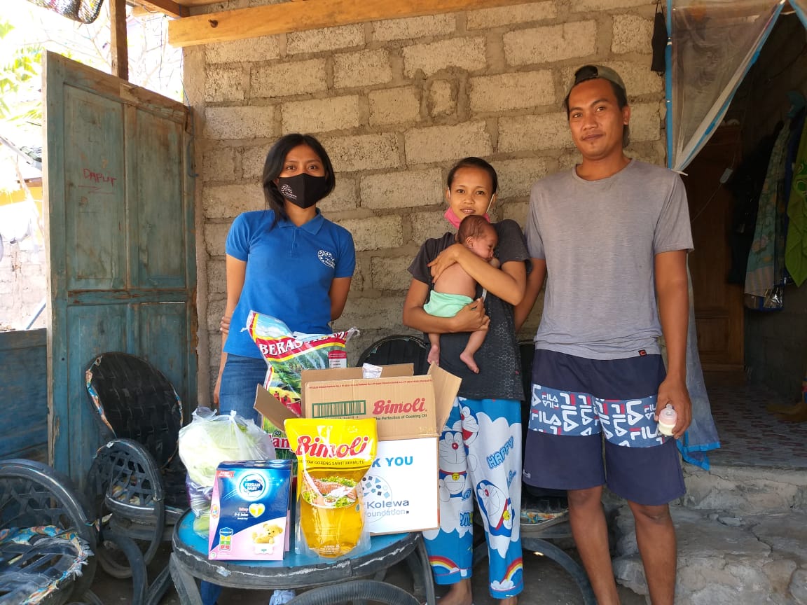 Een gezin op Bali met hun voedselpakketten.