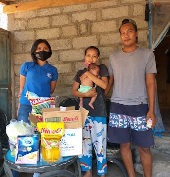 Een gezin op Bali met hun voedselpakketten.