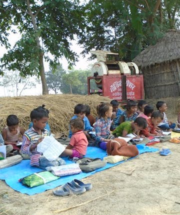 Een groep kinderen krijgt noodgedwongen buiten onderwijs in Nepal.