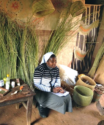 Een vrouw zit in haar schuur in Tanzania.