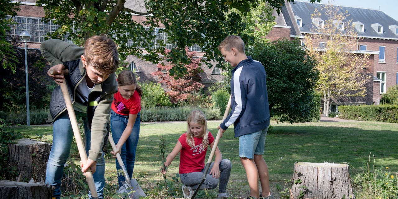 Kinderen die deelnemen aan Global Exploration planten een boom