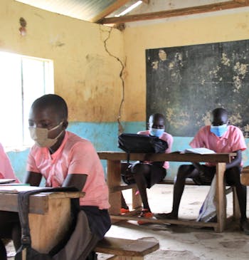 Kinderen met mondkapjes zitten in een klaslokaal in Kenia.