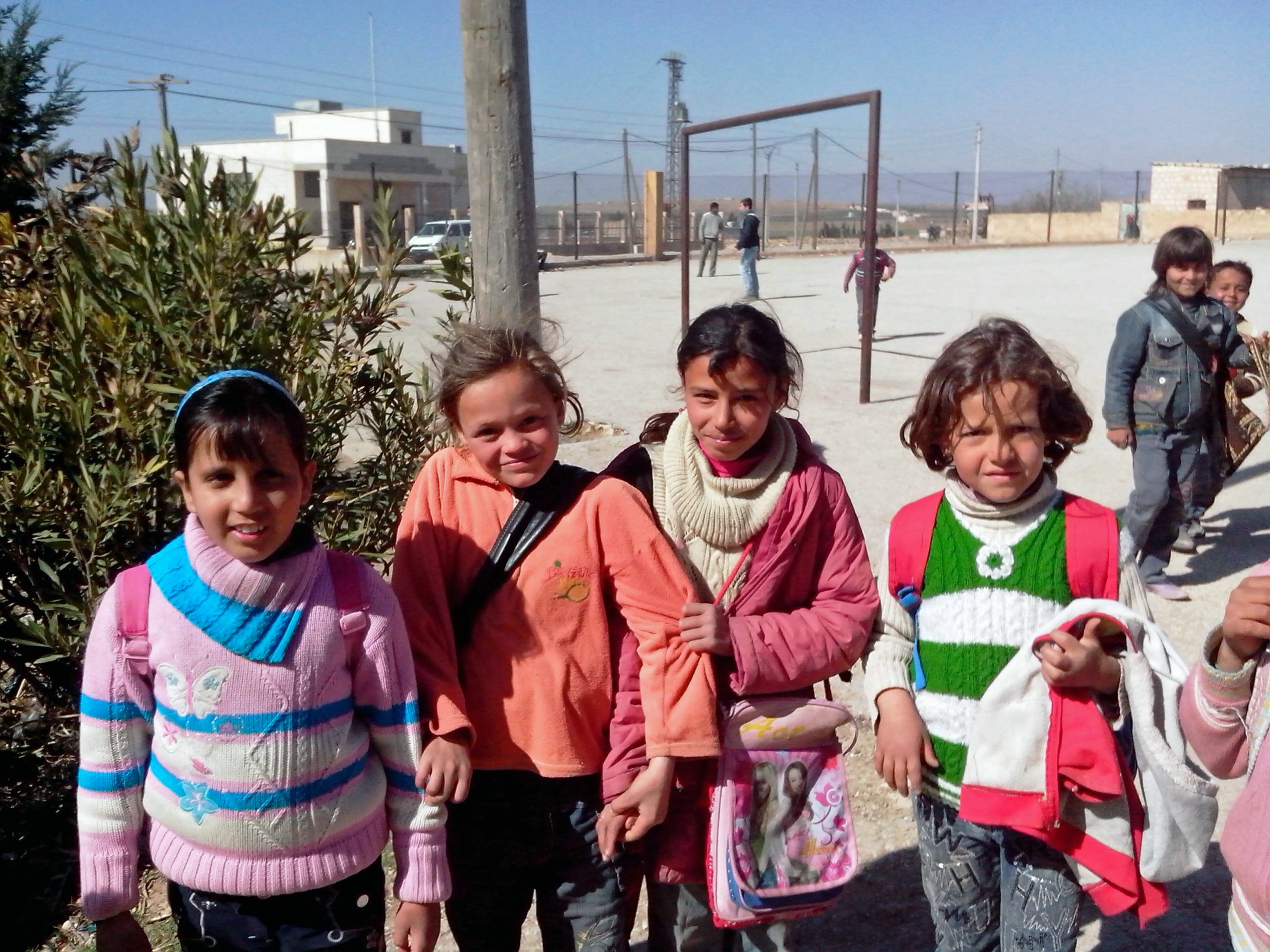 Vier meisjes op het schoolplein van hun school in Syrië.