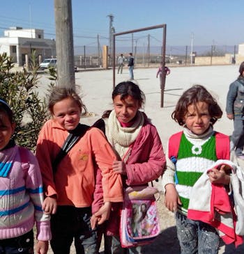 Vier meisjes op het schoolplein van hun school in Syrië.