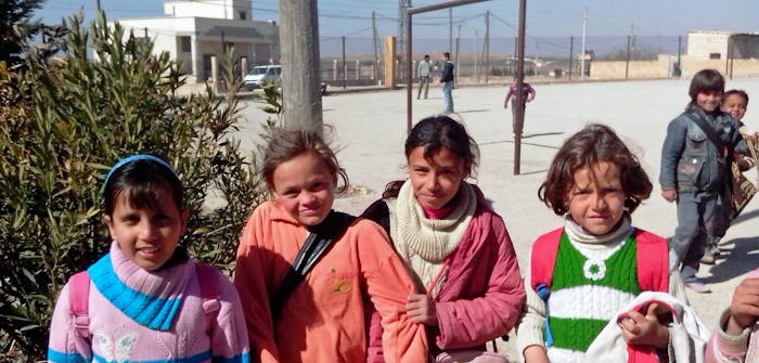 Vier meisjes op het schoolplein van hun school in Syrië.