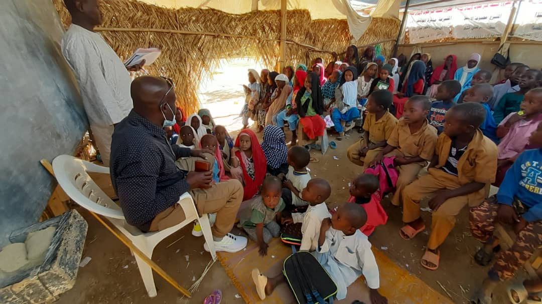 Een groep kinderen krijgt les in een tent in Tsjaad.