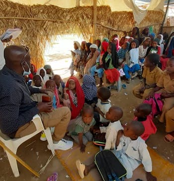 Een groep kinderen krijgt les in een tent in Tsjaad.