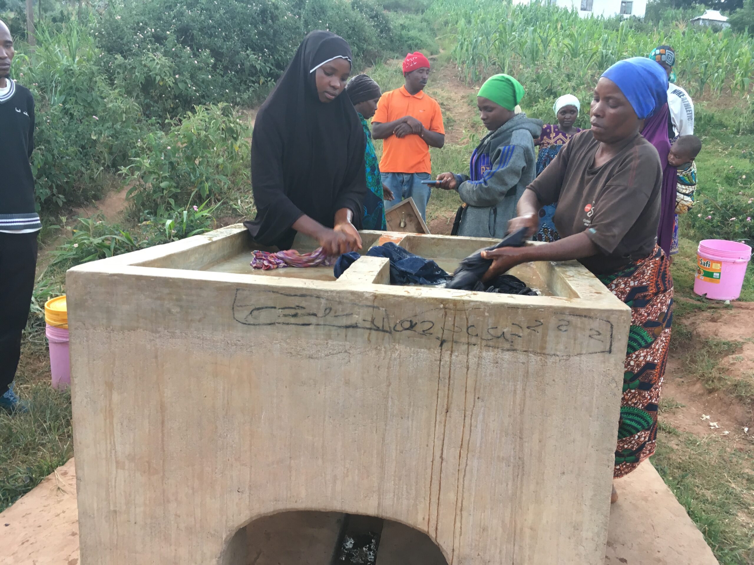 Een groep vrouwen doet de was bij een waterkraan in Tanzania.