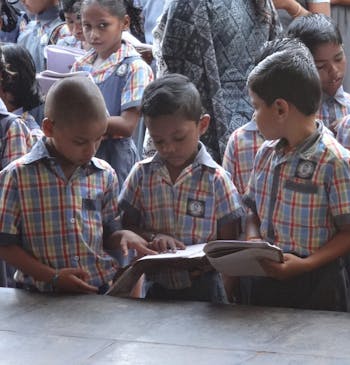 Vier schoolkinderen in India op hun schoolplein.