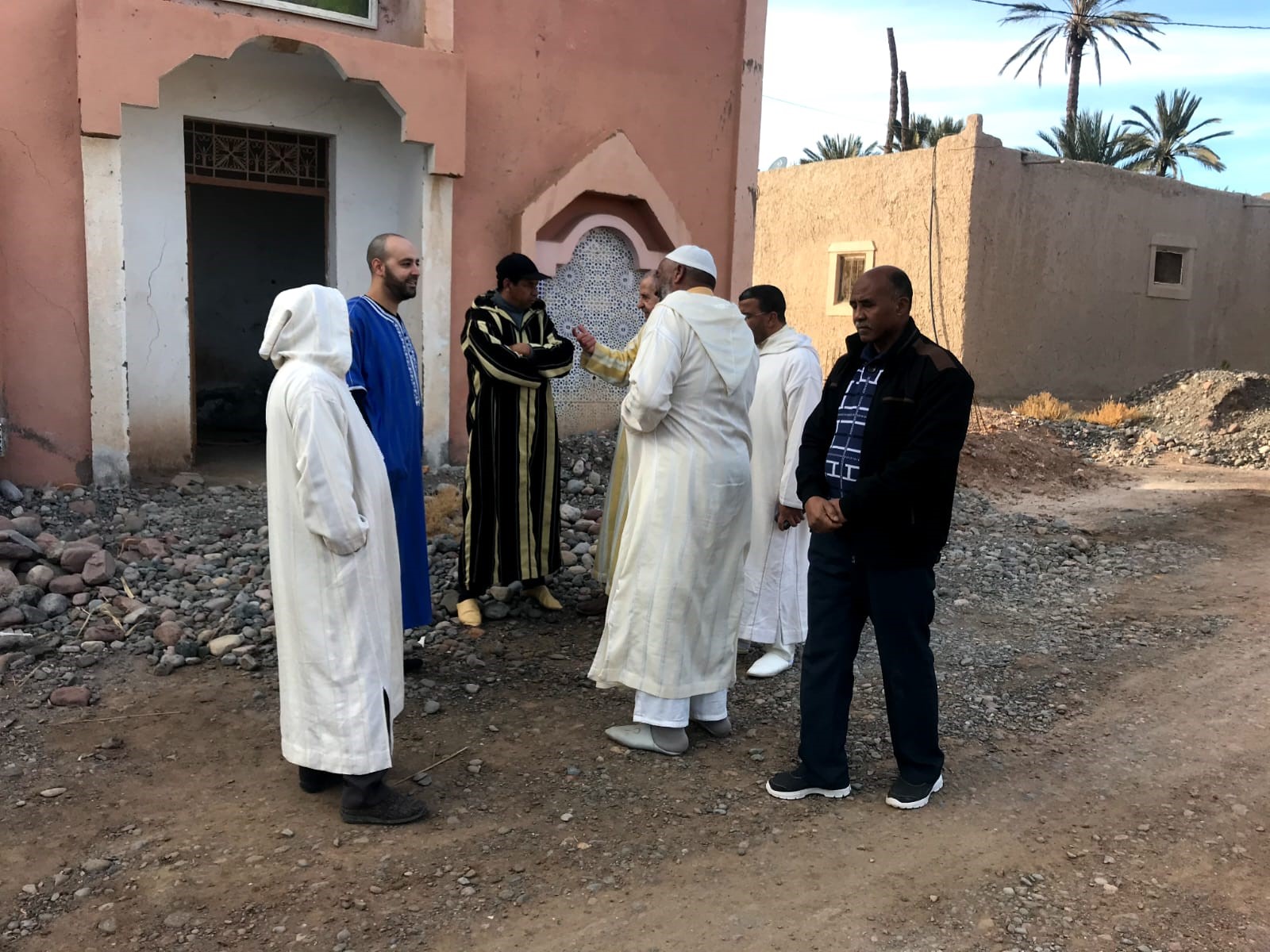 Een groep mannen vergadert voor een huis in Marokko.