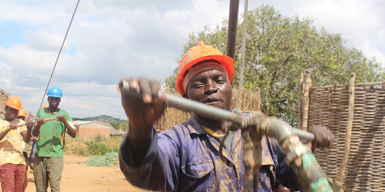Een man aan het werk bij een waterpomp in Zambia.