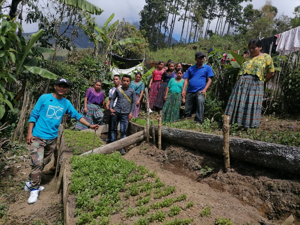 Een groep mensen poseert bij een groentetuin in Guatemala.