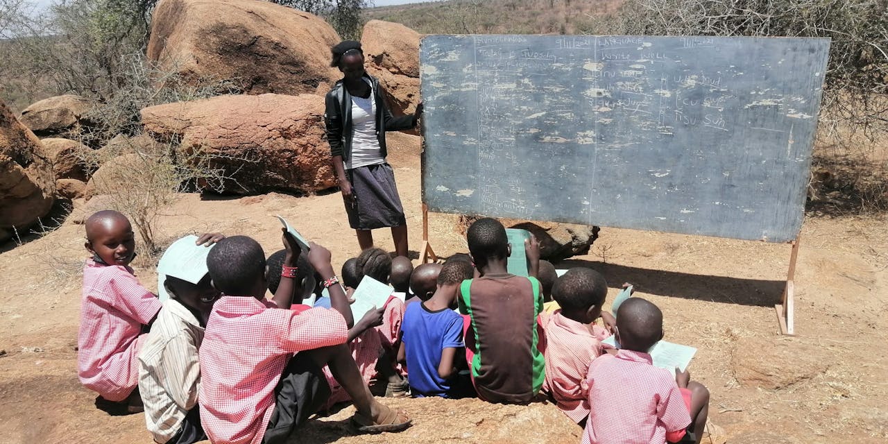 Een klasje kinderen krijgt buiten les in Kenia.
