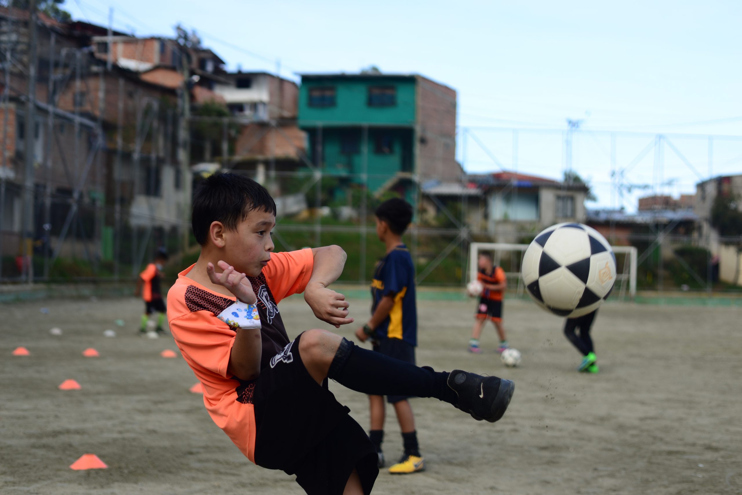 Een jongetje schiet een bal in Colombia.