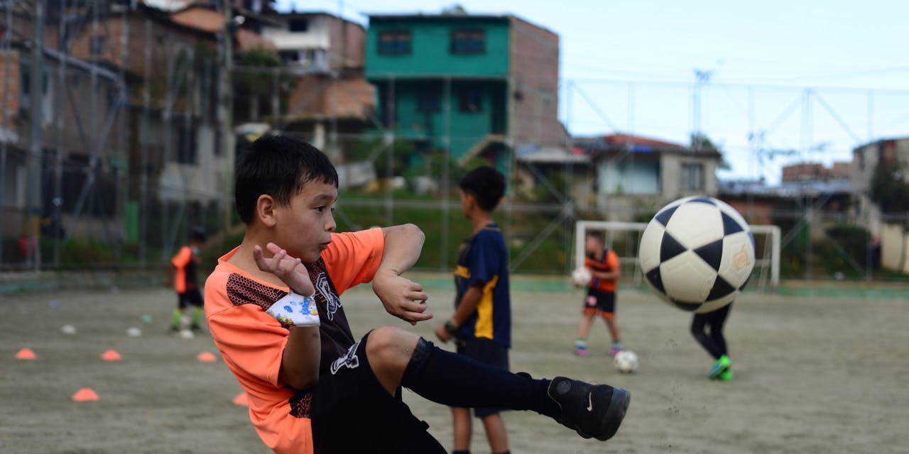 Een jongetje schiet een bal in Colombia.