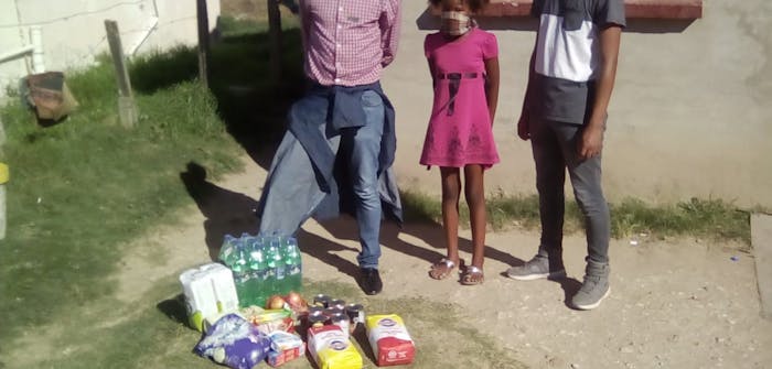 Een gezin uit Zuid-Afrika met een voedselpakket.