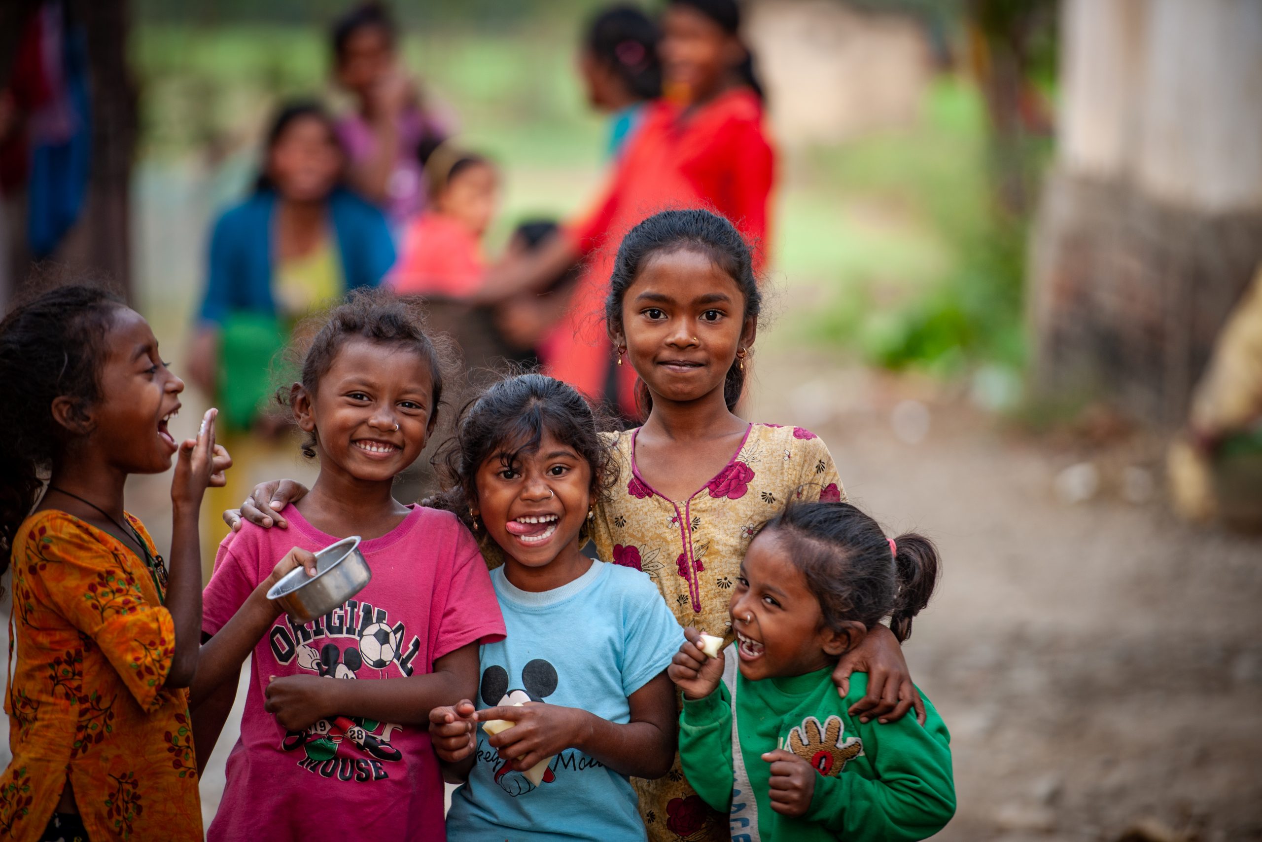 5 jonge kinderen kijken lachend in de camera in Nepal.