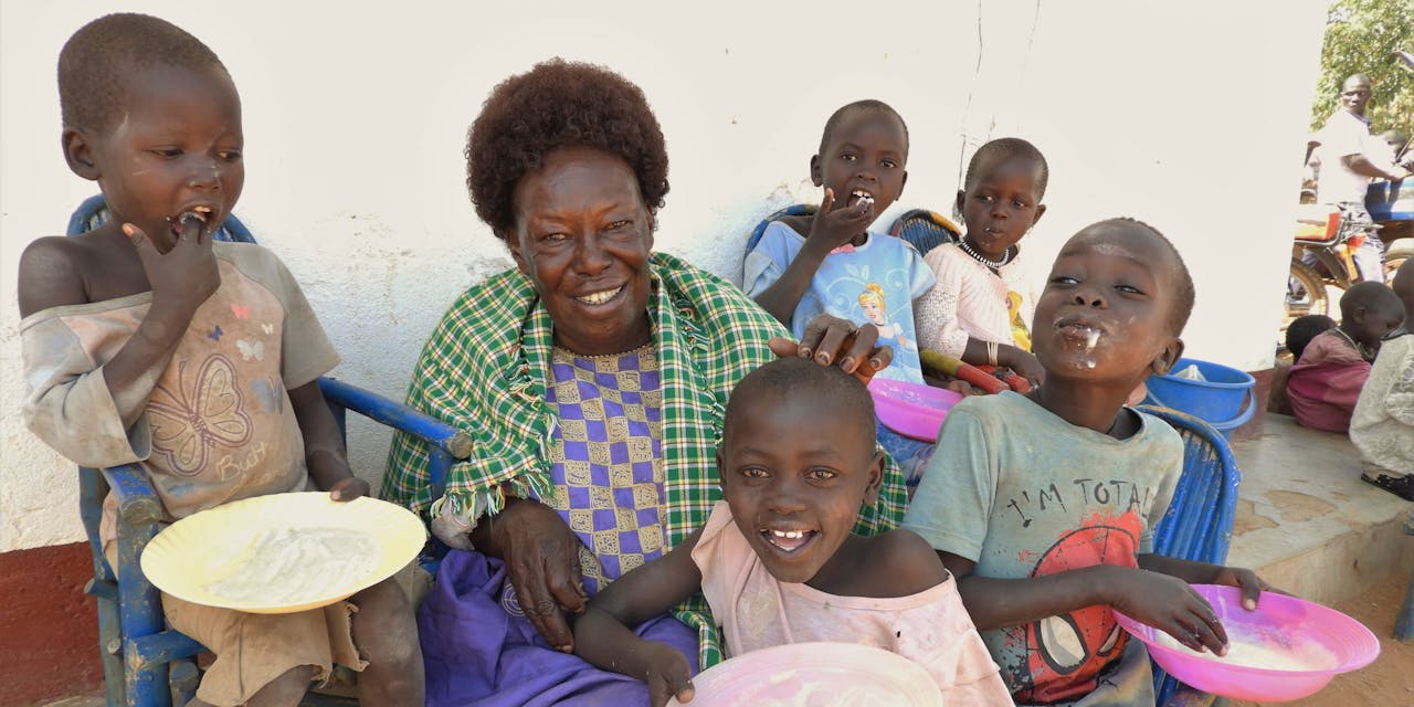 Een vrouw met een groep kinderen in Oeganda.