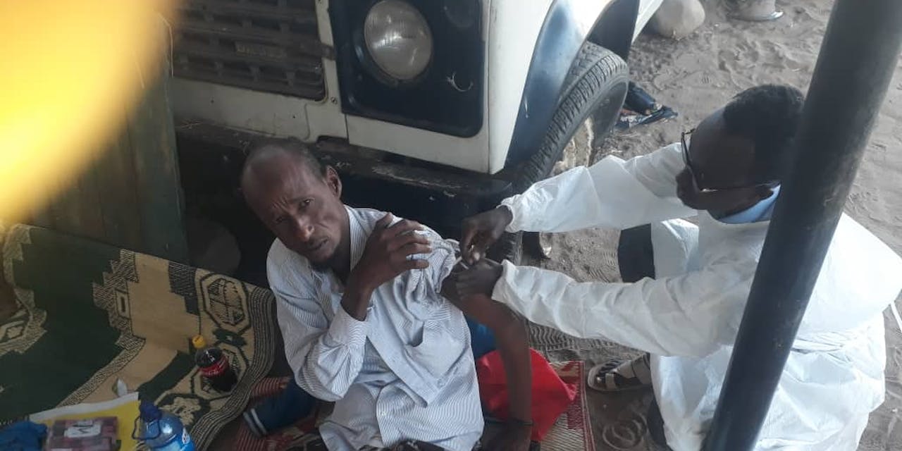 Een arts in Somalië geeft een inenting aan een patiënt.