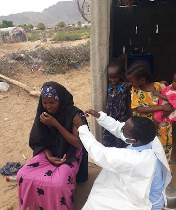 Een vrouw krijgt een vaccin toegediend in Somalië
