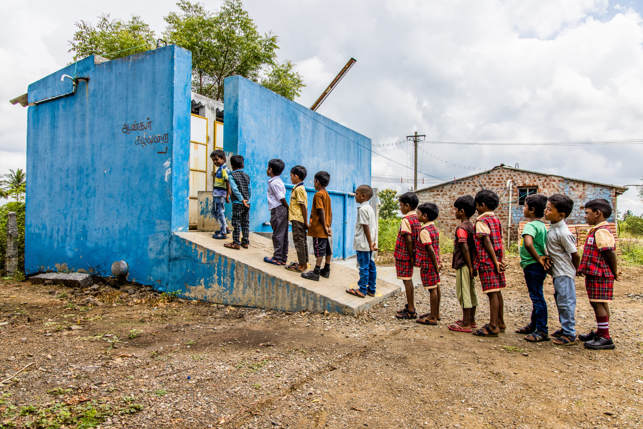Kinderen in de rij voor het toilet in India.