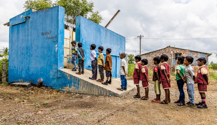 Kinderen in de rij voor het toilet in India.