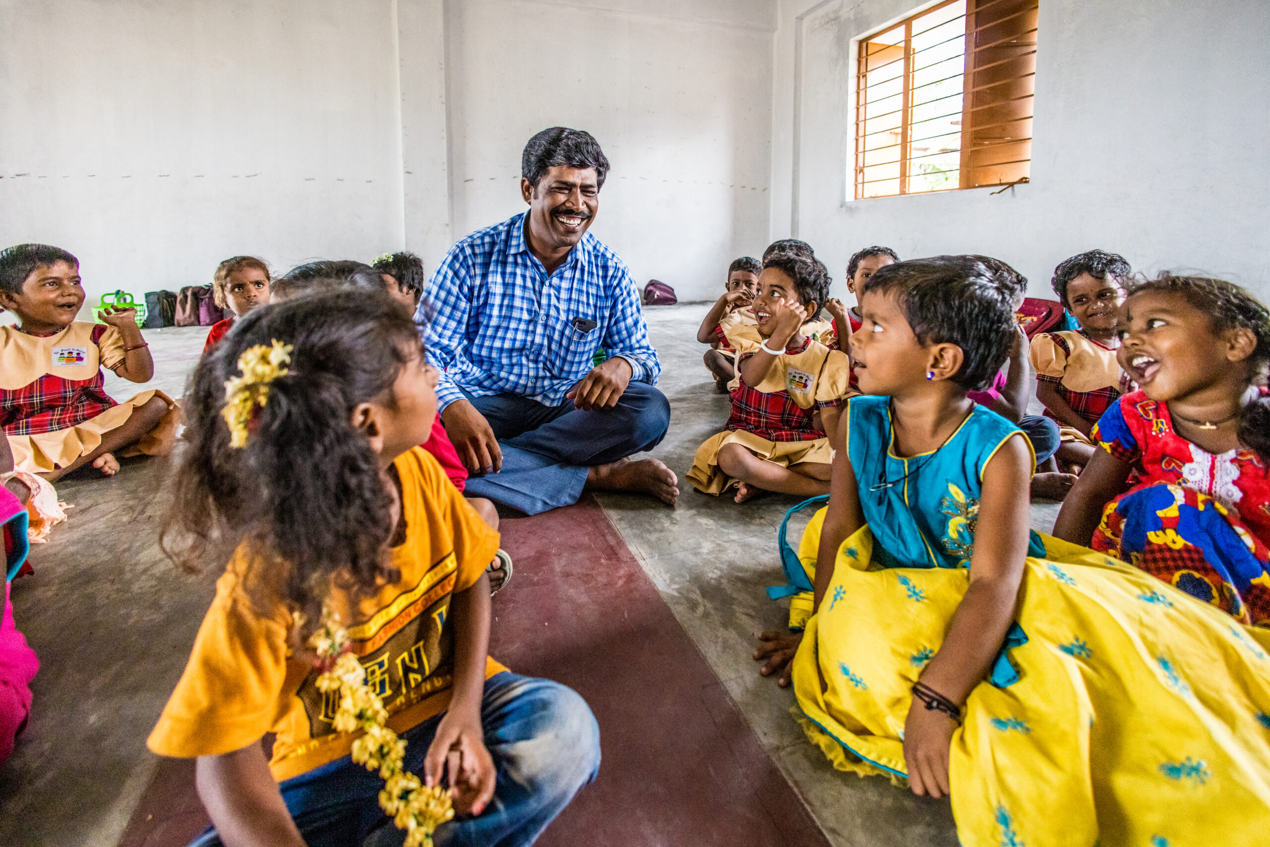 Raja omringt door scholieren in de klas in India.