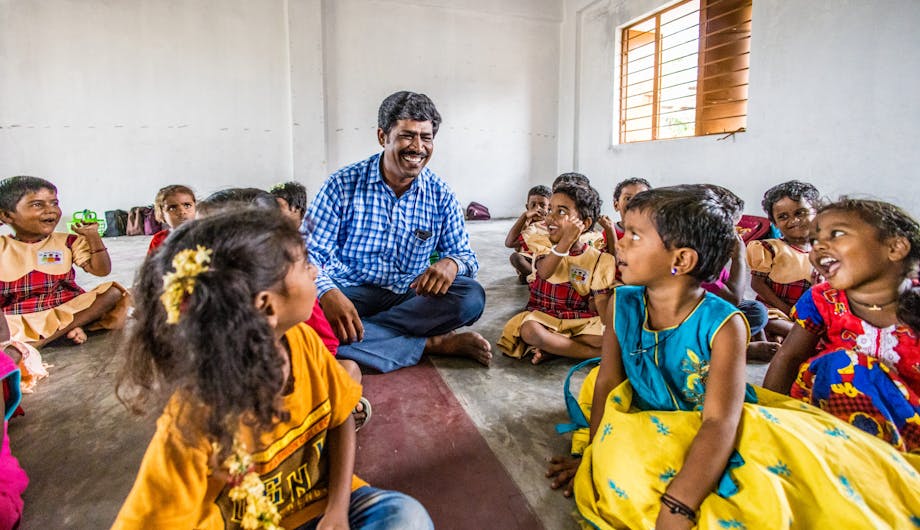 Raja omringt door scholieren in de klas in India.