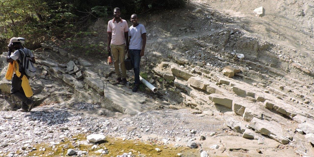 Twee mannen aan de oever van een stroompje in Haïti.