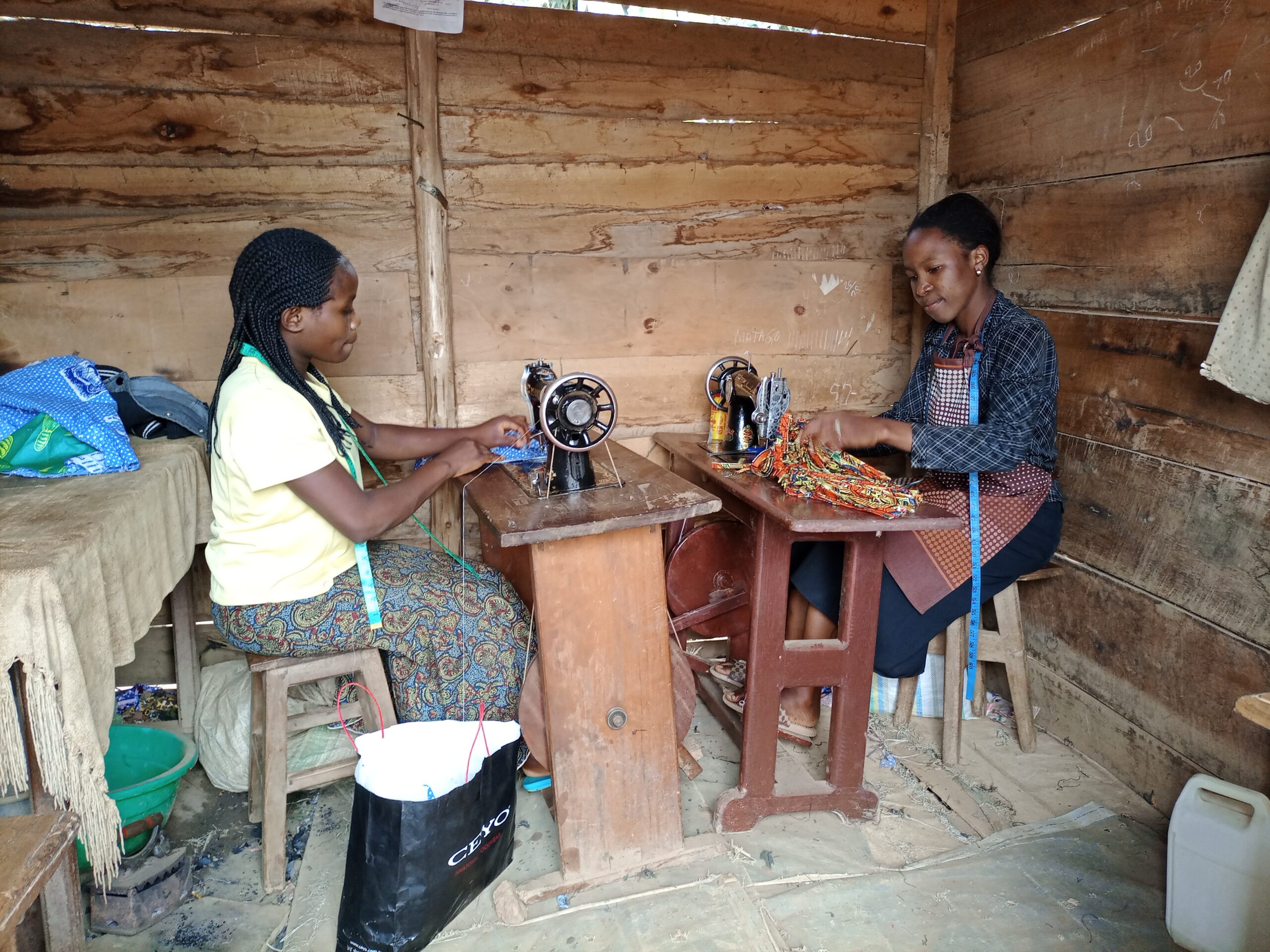 Twee meisjes aan het werk in een naaiatelier in Congo.