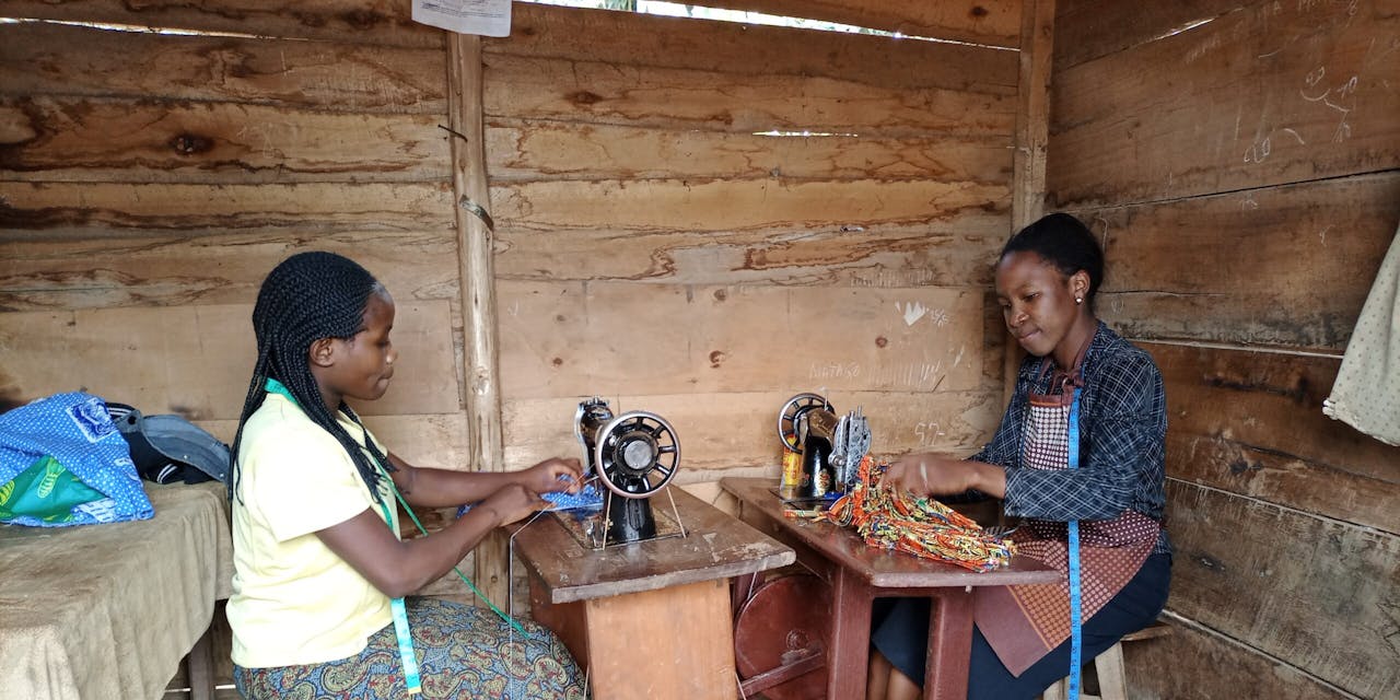 Twee meisjes aan het werk in een naaiatelier in Congo.