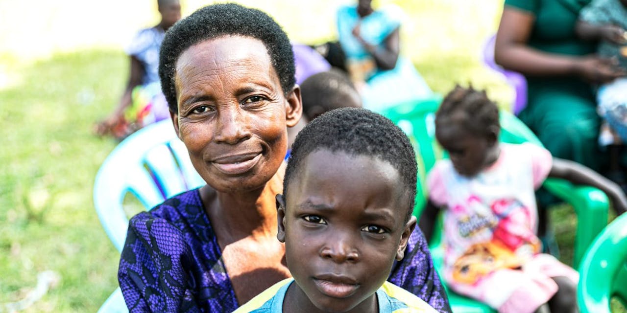 Een kind met zijn pleegmoeder in Oeganda.