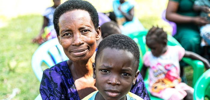 Een kind met zijn pleegmoeder in Oeganda.