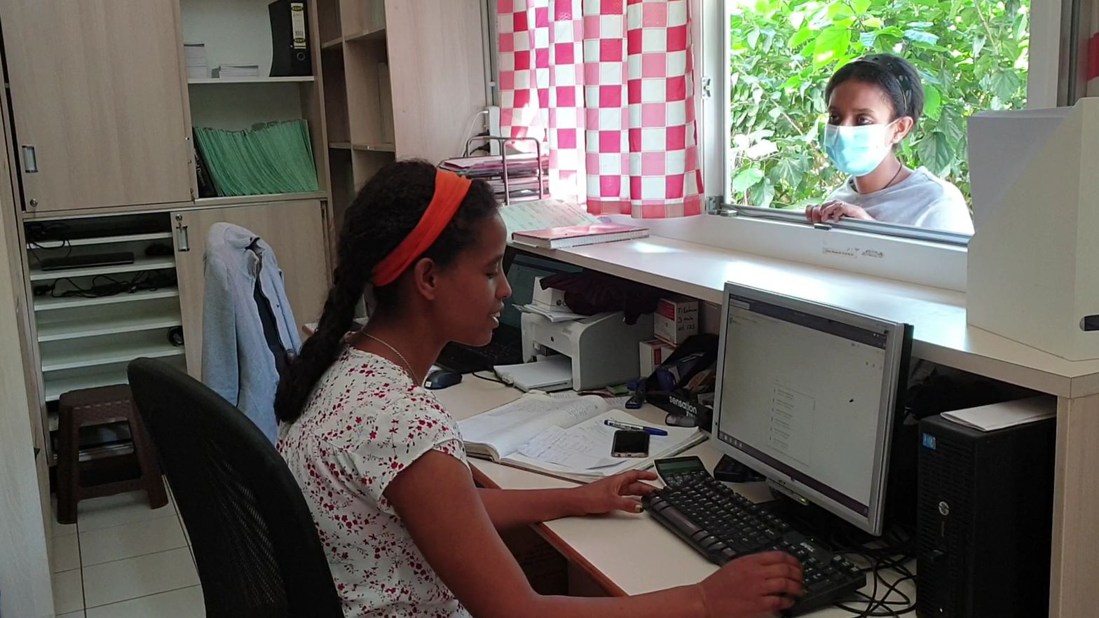 Een receptioniste van een ziekenhuis werkt in een digitaal patiëntendossier in Ethiopië.