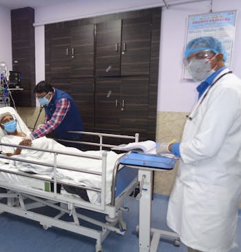 Een man ligt in een ziekenhuisbed op de spoedeisende hulp in India.