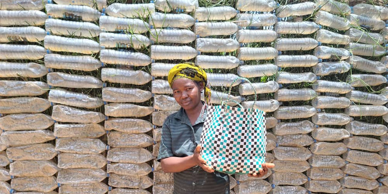 Een vrouw toont een gerecycled tas in Oeganda.