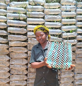 Een vrouw toont een gerecycled tas in Oeganda.