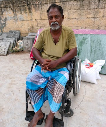 Een Indiase man in een rolstoel.