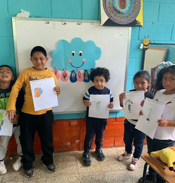 Kinderen laten een tekening zien op school in Guatemala.