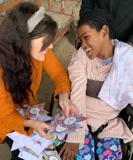 Ine overhandigt de kaarten aan een meisje met een beperking in Zuid Afrika.