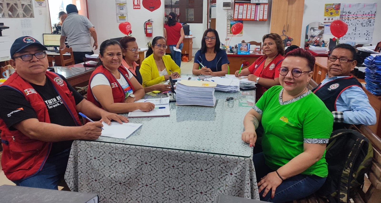 Een groep begeleiders in Peru ondertekent documenten.
