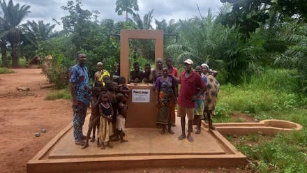 Een groep mensen bij een waterpomp in Benin