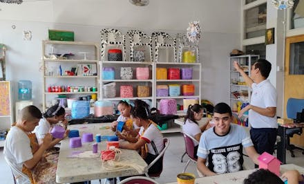 Jongeren met een beperking in Colombia bij een schilderwerkplaats